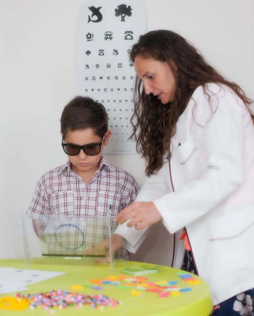 Profesional realizando una sesi&oacute;n de terapia visual con un ni&ntilde;o en &Oacute;ptica Zocovisi&oacute;n, en Toledo.